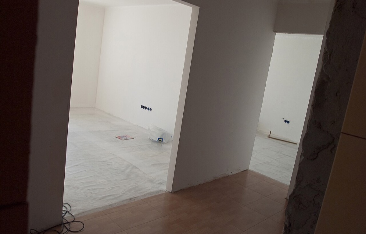 Fresh plasterwork and unfinished patches on a white interior wall