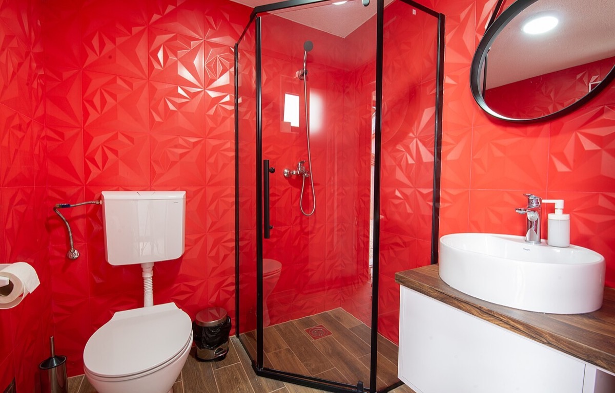 Modern bathroom with tiled walls and a glass shower screen