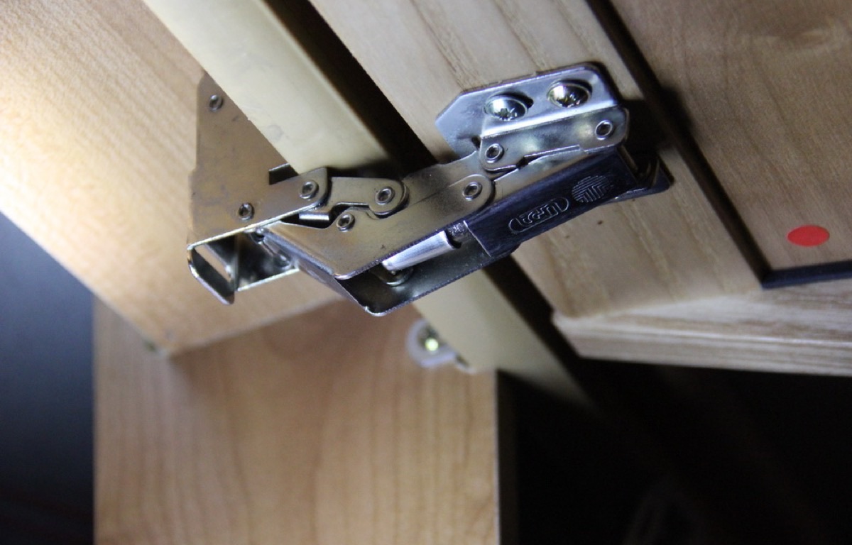Close view of metal cabinet hinge hardware