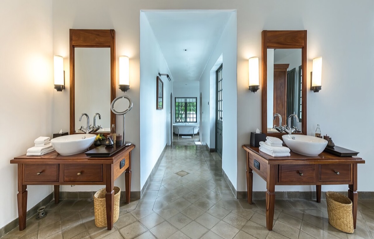 Clean bathroom with a bathtub, vanity and folded towels