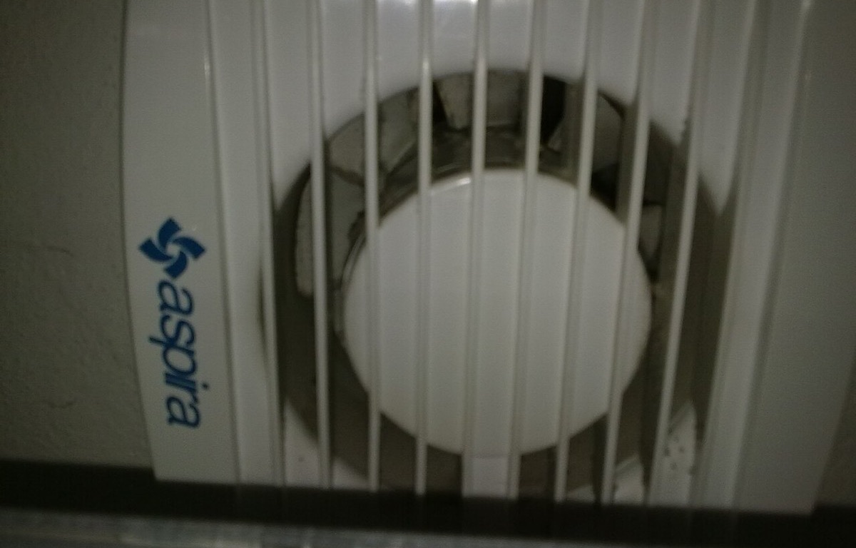 Bathroom exhaust fan fitted high on a tiled wall