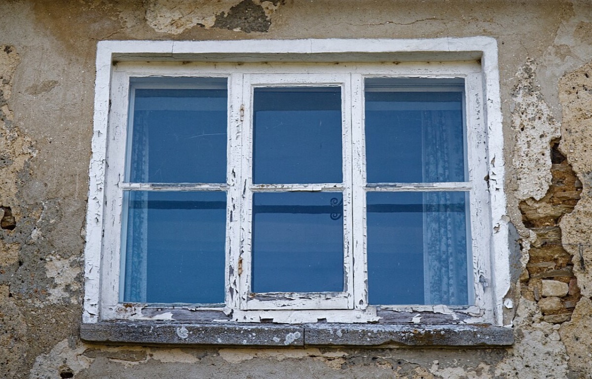 Weathered window frame with peeling exterior paint