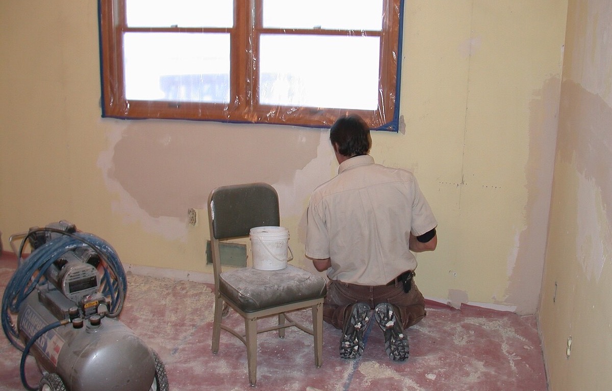 Patched areas on a plaster wall during repair