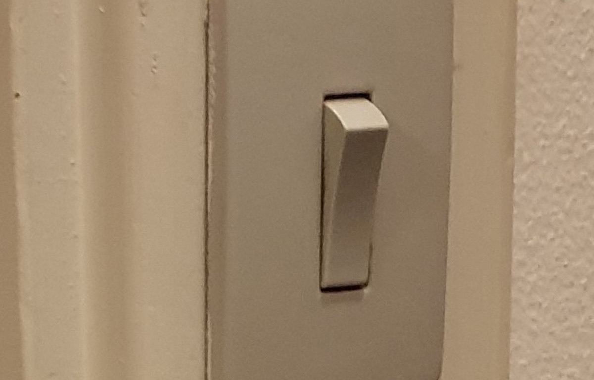 Two wall switches above a switched electrical socket