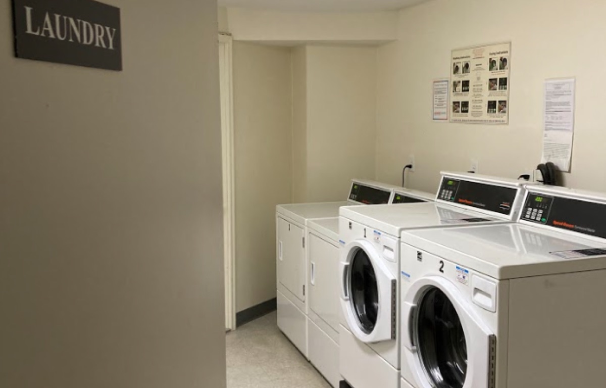 Two washing machines and two dryers in an apartment laundry room