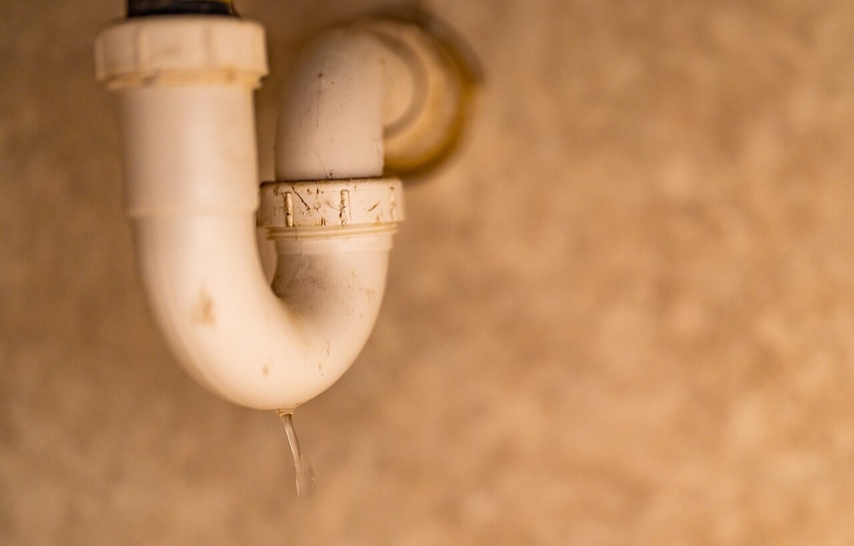 White PVC P-trap and plumbing beneath a bathroom sink