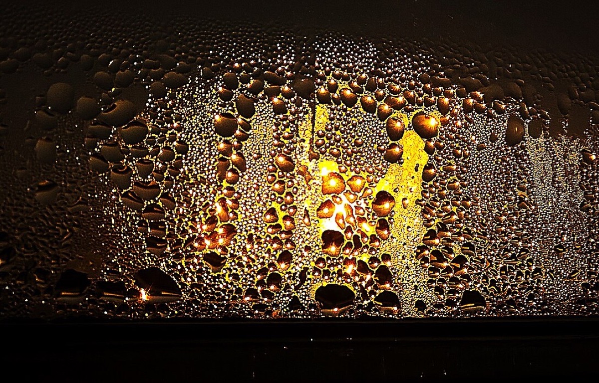 Condensation covering a window at sunset